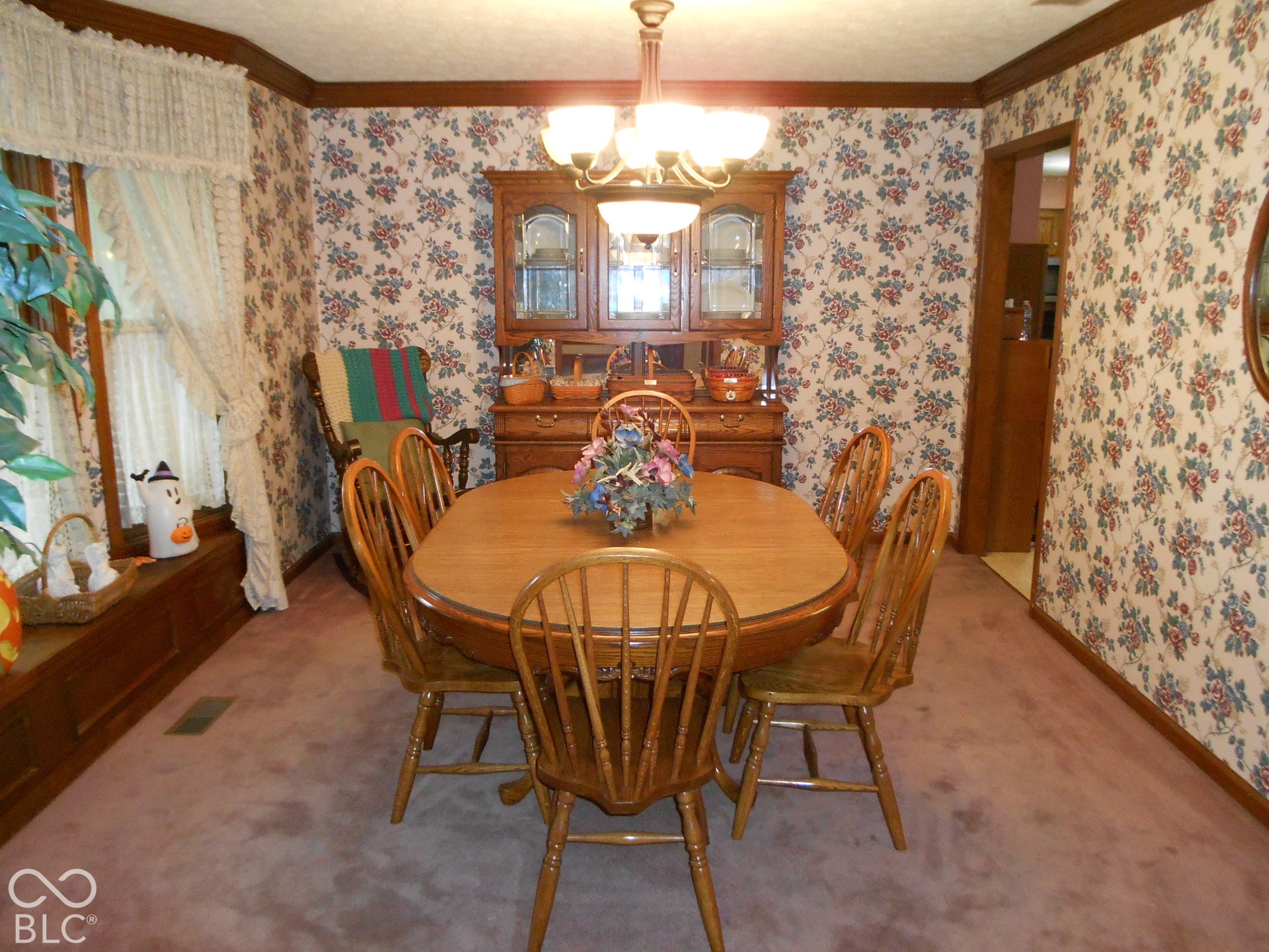 Wall-to-wall carpeting with a floral-patterned wall covering, Crown moulding.