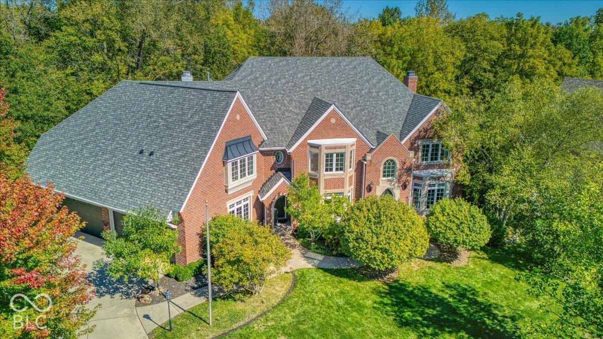 Brick exterior with a multi-gabled roof, multiple bay windows, and an attached two-car garage