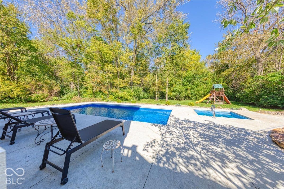 Expansive backyard with an in-ground swimming pool, an attached spa, and a concrete pool deck