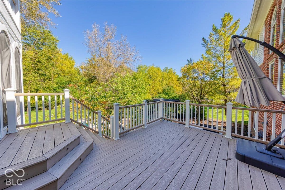 Expansive deck with gray composite decking, white railings, and integrated stair lighting