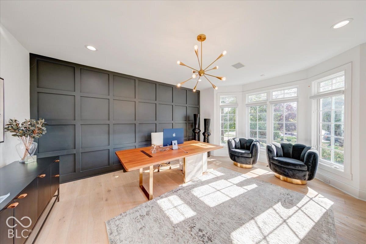 Board and batten accent wall, expansive bay windows, wood-finish flooring, and a contemporary sputnik chandelier