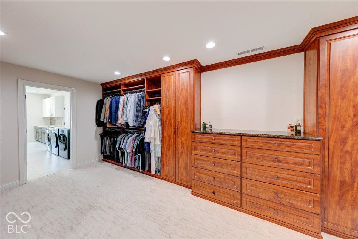 Custom built-in wood cabinetry with integrated shelving and drawers, recessed lighting, and a stone countertop