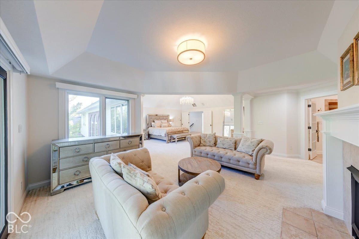 Vaulted ceilings, a built-in fireplace, expansive windows, and a large open concept layout
