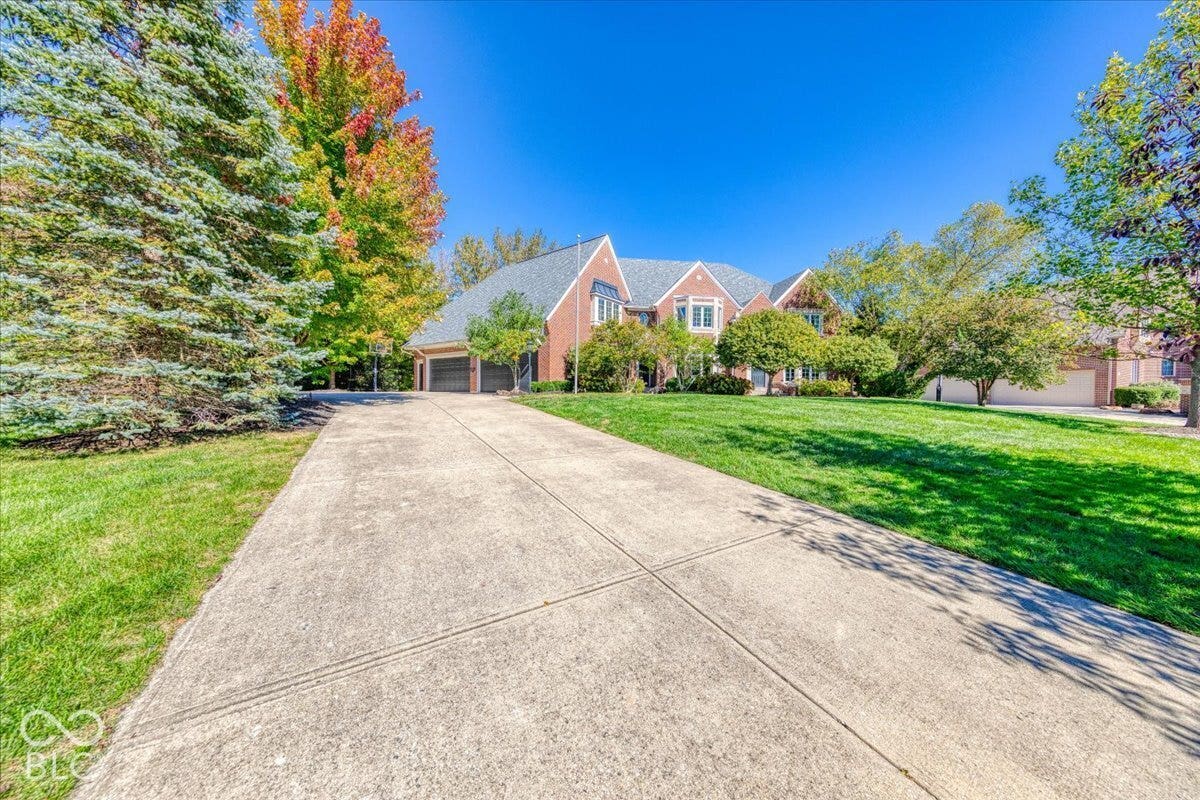 Brick exterior, multi-pane windows, dormer windows, attached garage, concrete driveway