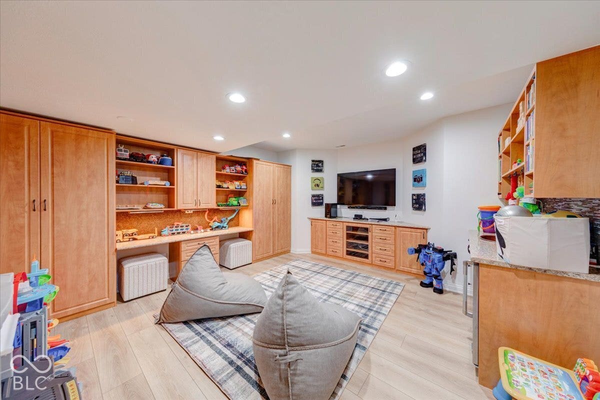 Recessed lighting illuminates wood-finish flooring