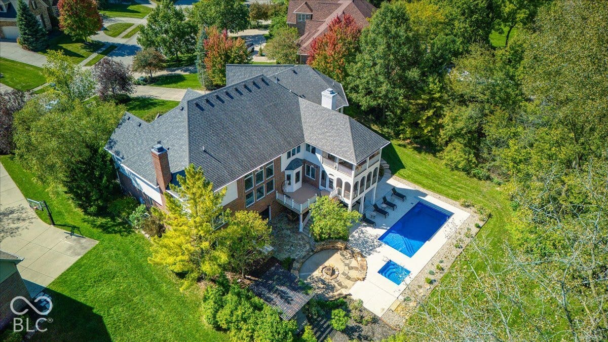 Expansive property featuring a multi-level structure, a dark shingle roof, and a prominent chimney