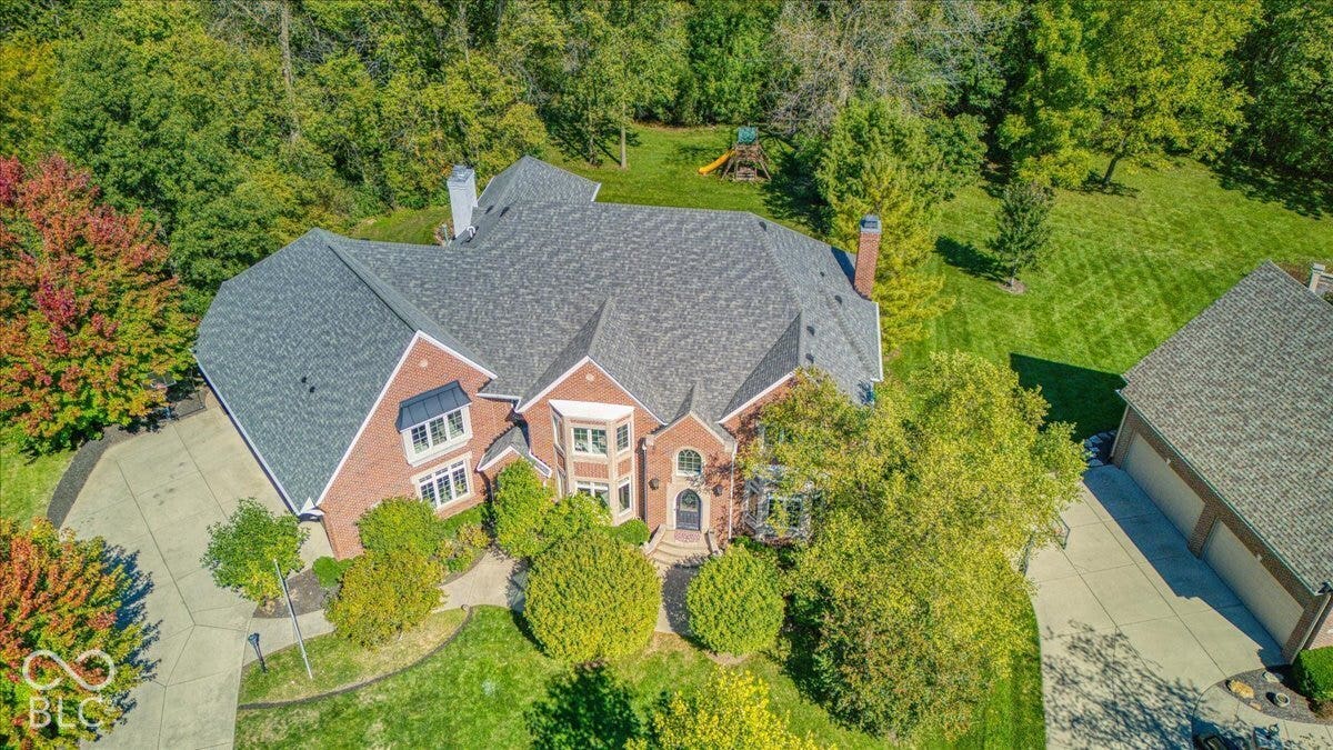 Brick exterior with multiple gables and a large paved driveway