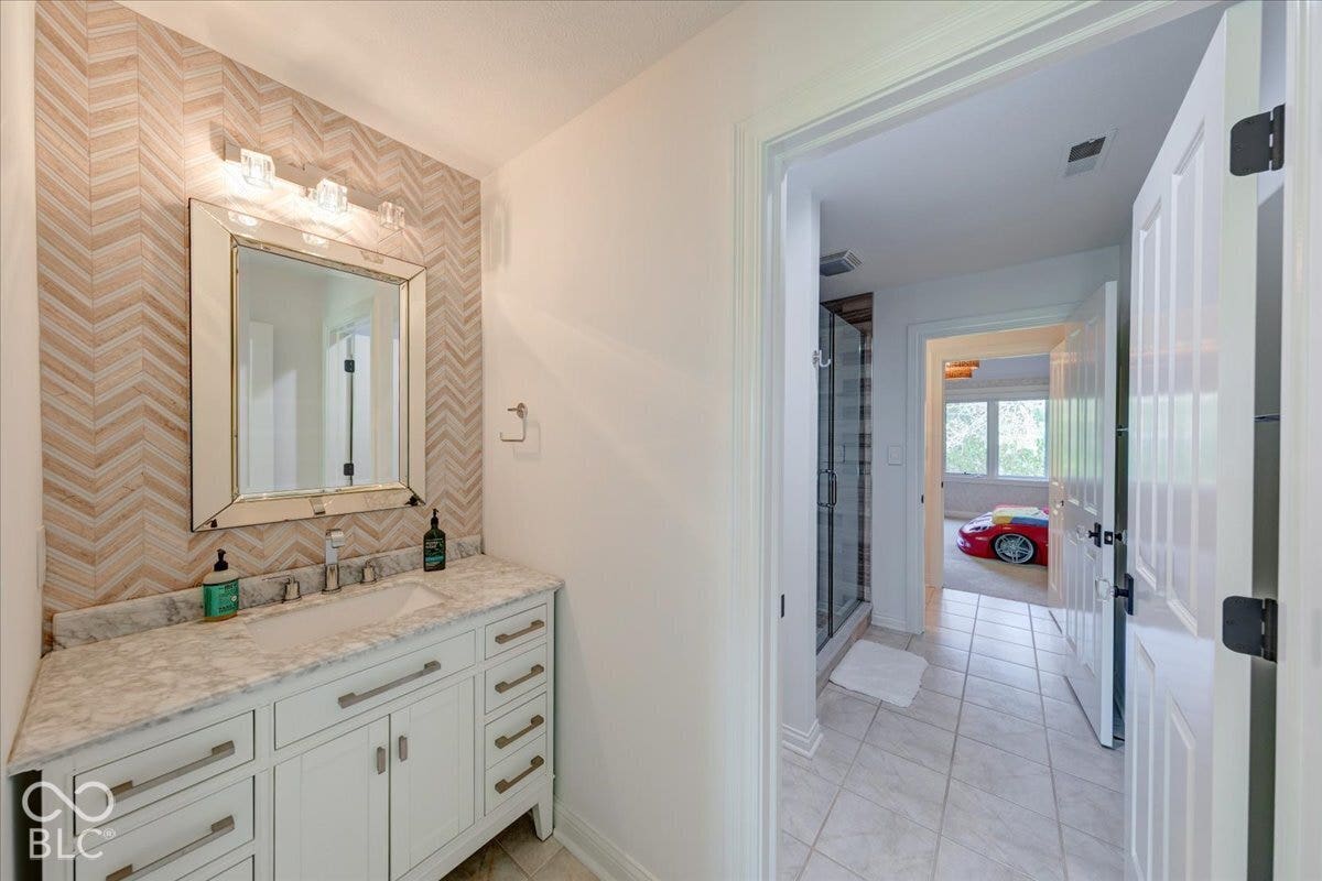 White vanity with brushed nickel hardware, single basin, and light-toned countertop