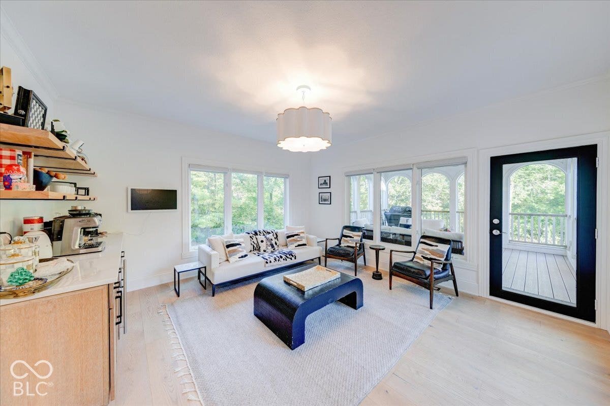 Wood-finish flooring throughout, white walls, and a recessed ceiling with a contemporary light fixture