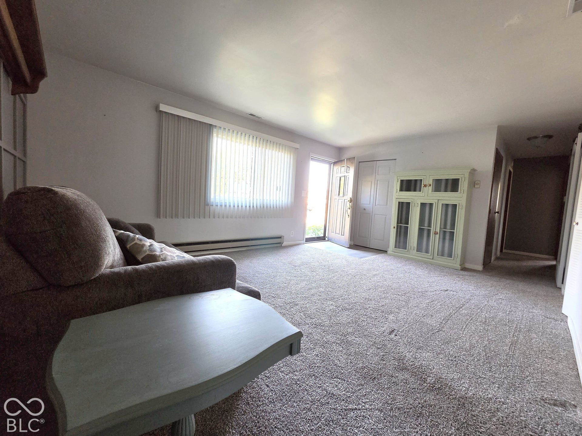 1221 Elk Lane, Elwood, IN 46036 Open floor plan featuring wall-to-wall carpeting, built-in display cabinetry, vertical window blinds, and recessed lighting