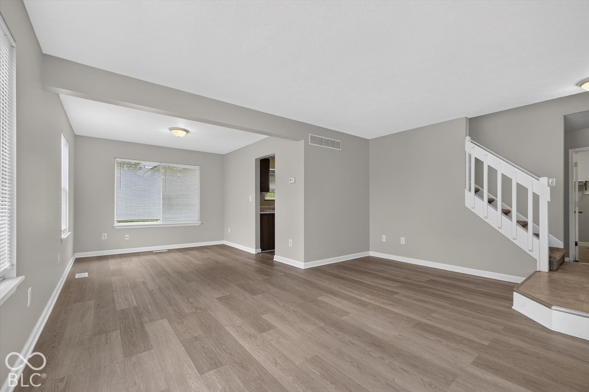 Dining area and living room with abundant natural light and neutral paint