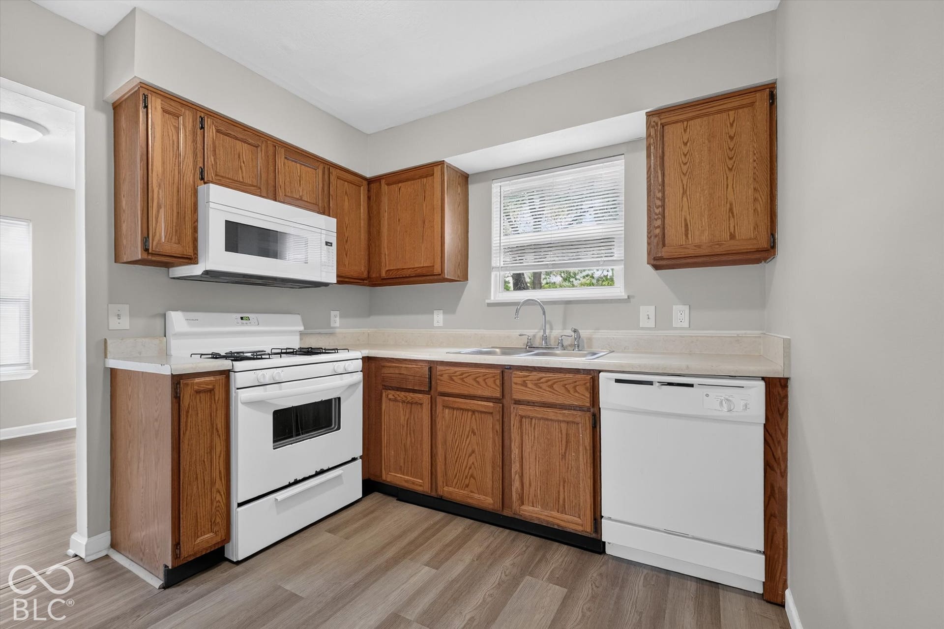 Kitchen featuring wood-finish cabinetry and white appliances
