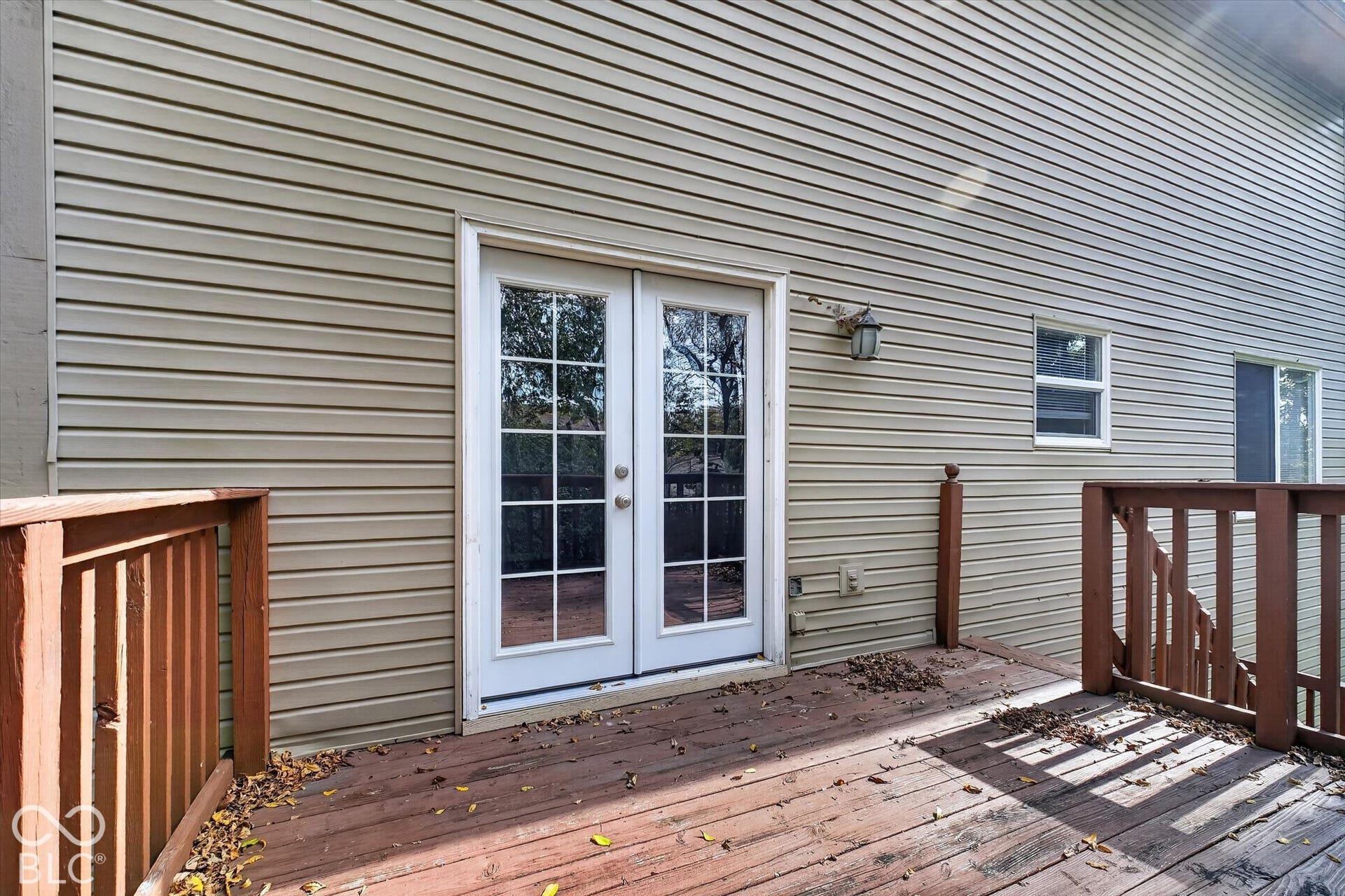 Wood-finish deck with a perimeter railing and mature trees