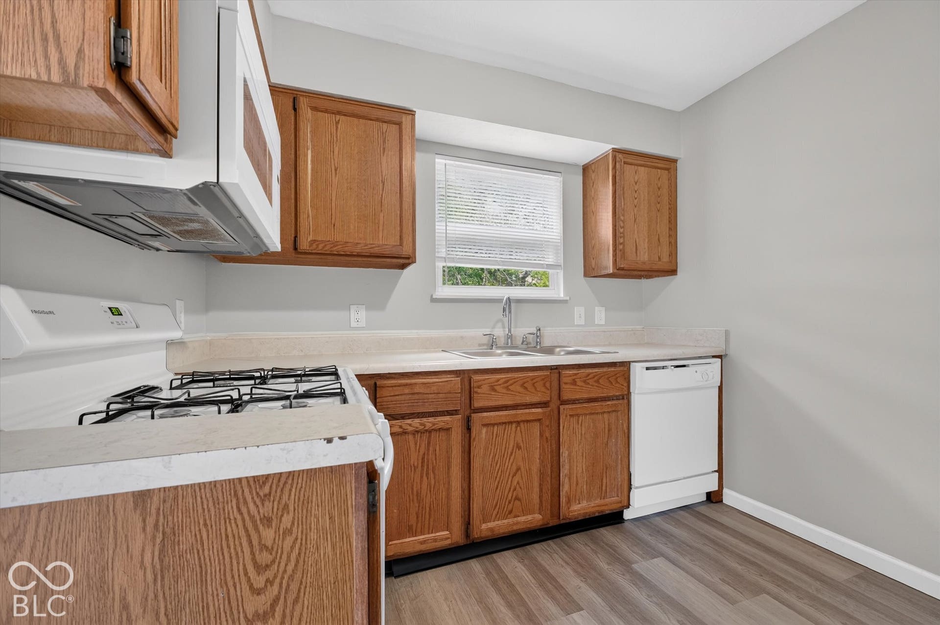 Kitchen featuring wood-finish cabinetry and white appliances