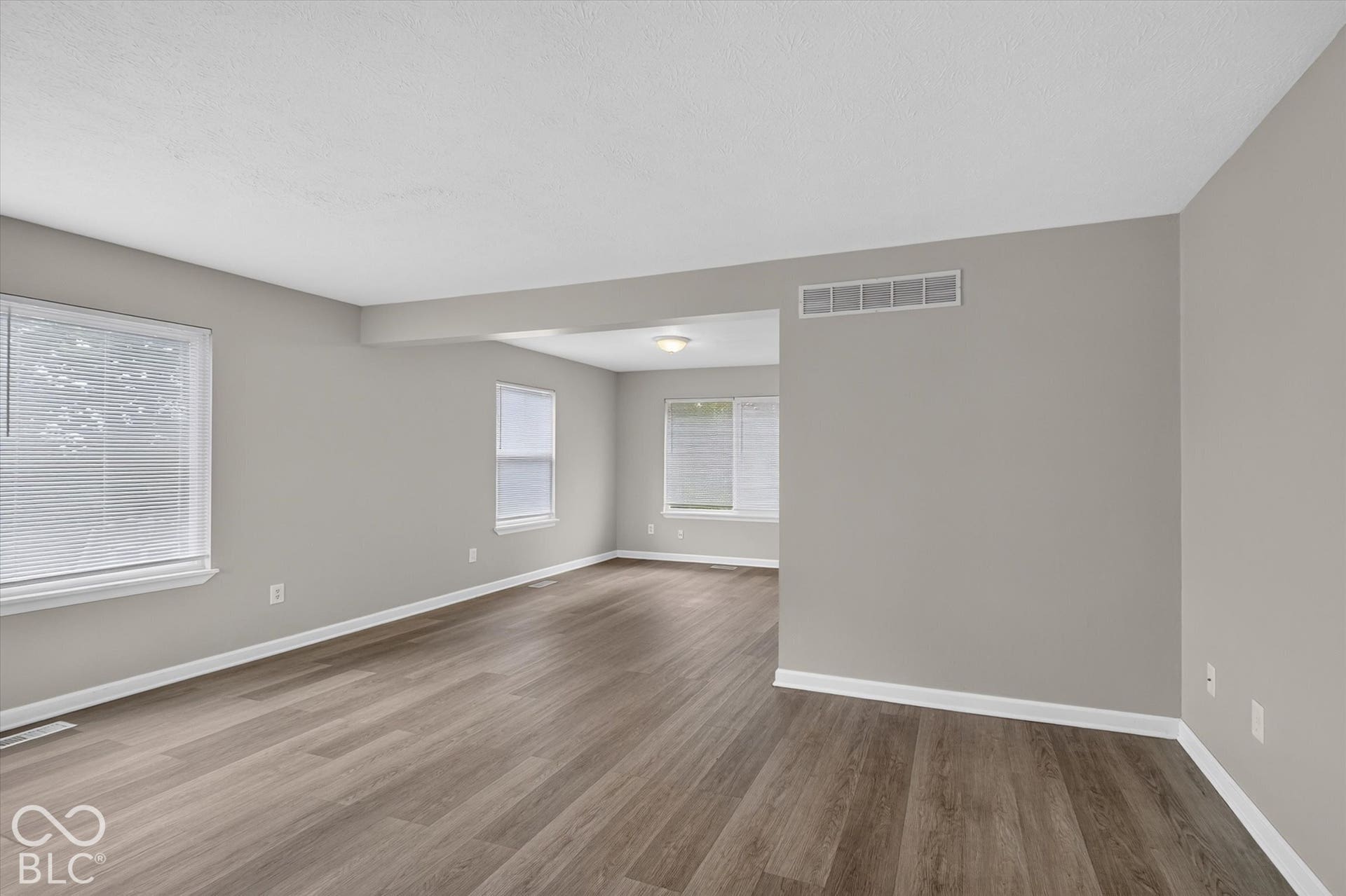 Living room and entryway with abundant natural light and neutral paint