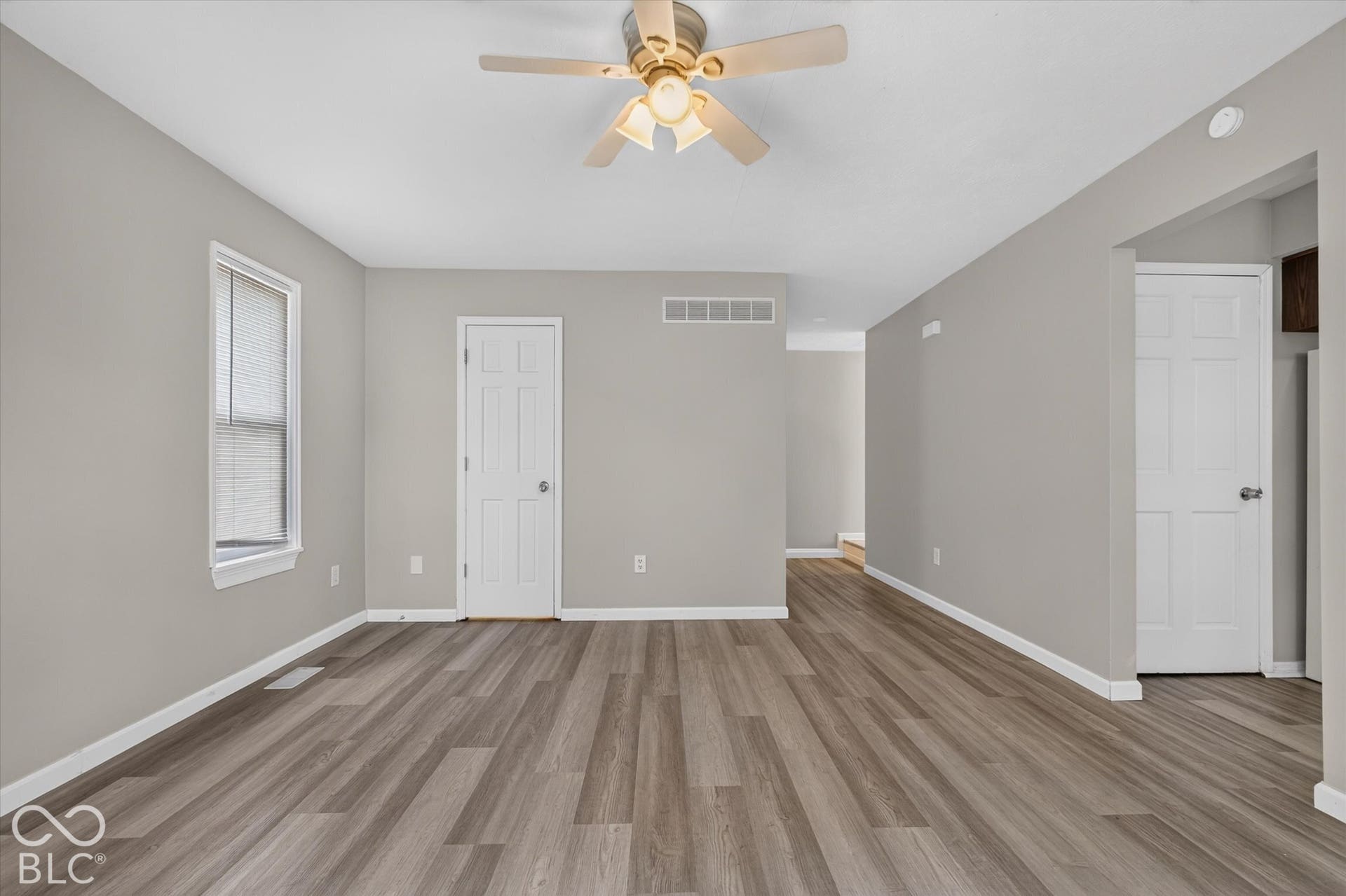 Spacious family room with backyard access, a ceiling fan, and neutral paint