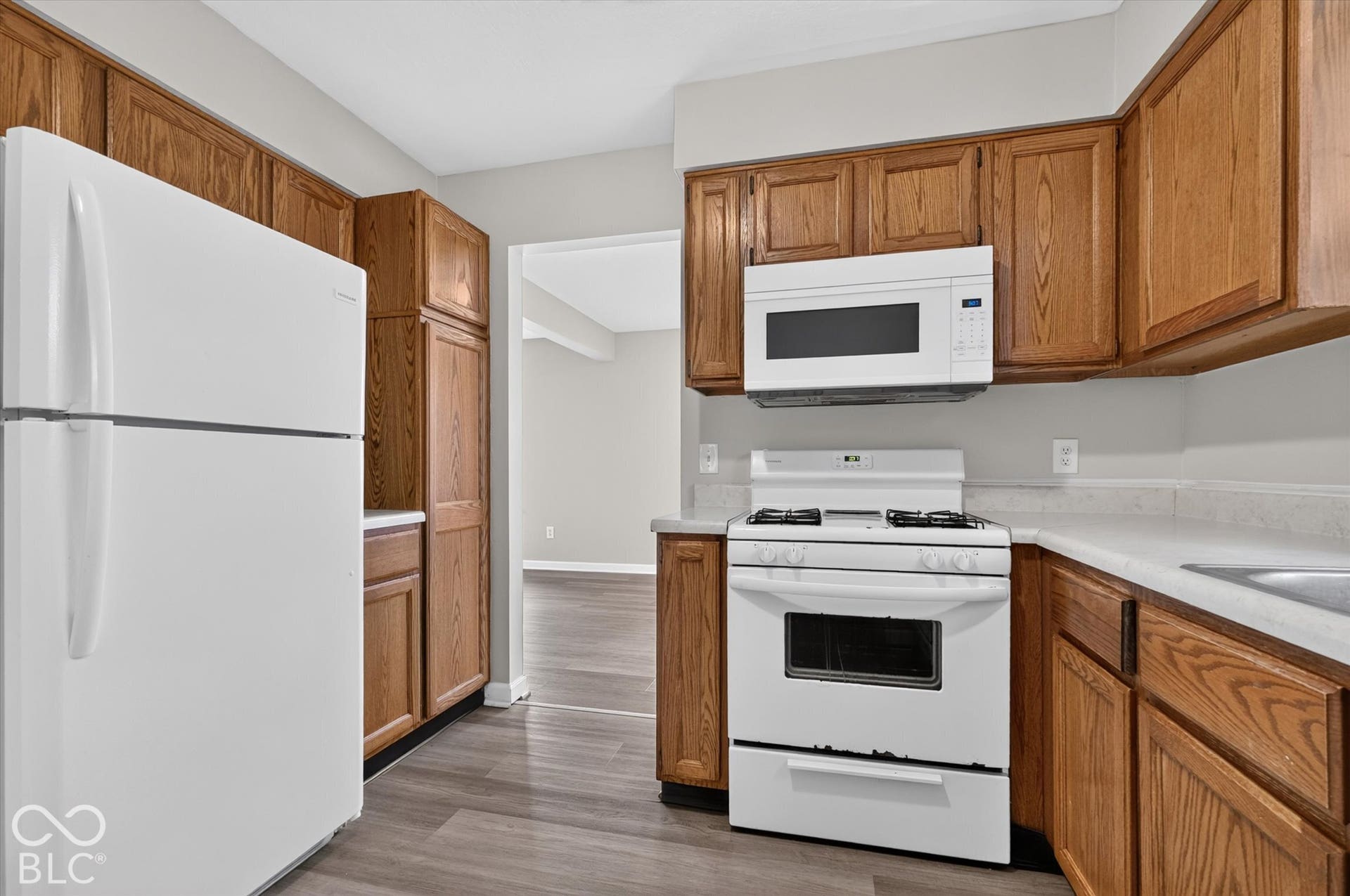 Kitchen featuring wood-finish cabinetry and white appliances