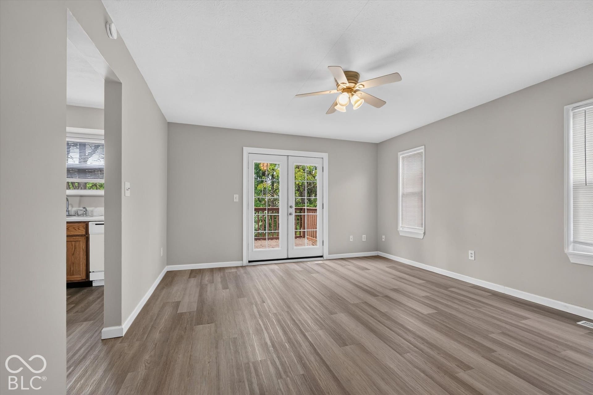 Spacious family room with backyard access, a ceiling fan, and neutral paint