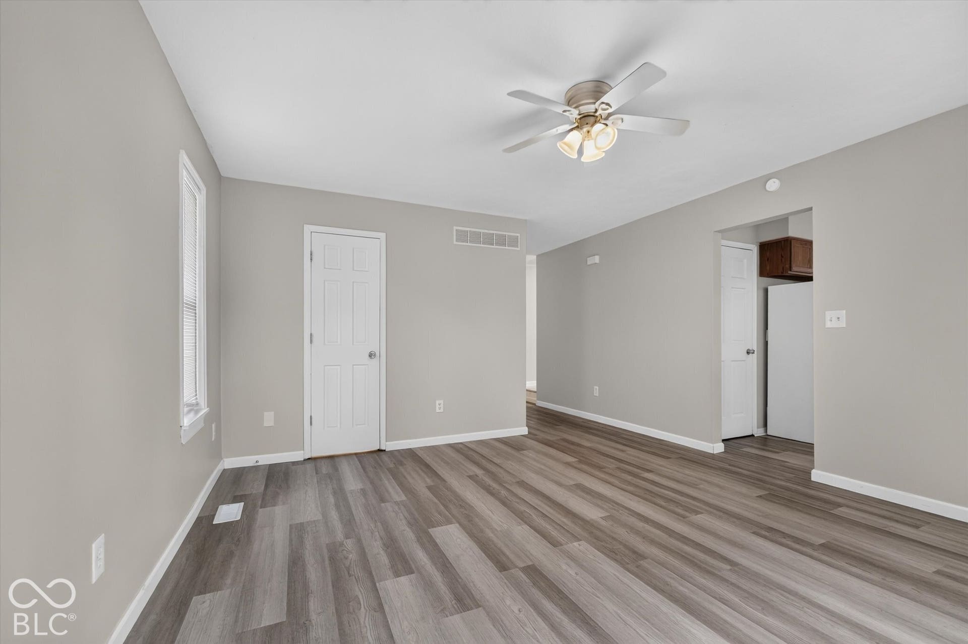 Spacious family room with backyard access, a ceiling fan, and neutral paint