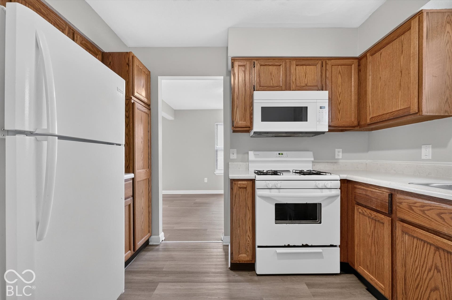 Kitchen featuring wood-finish cabinetry and white appliances