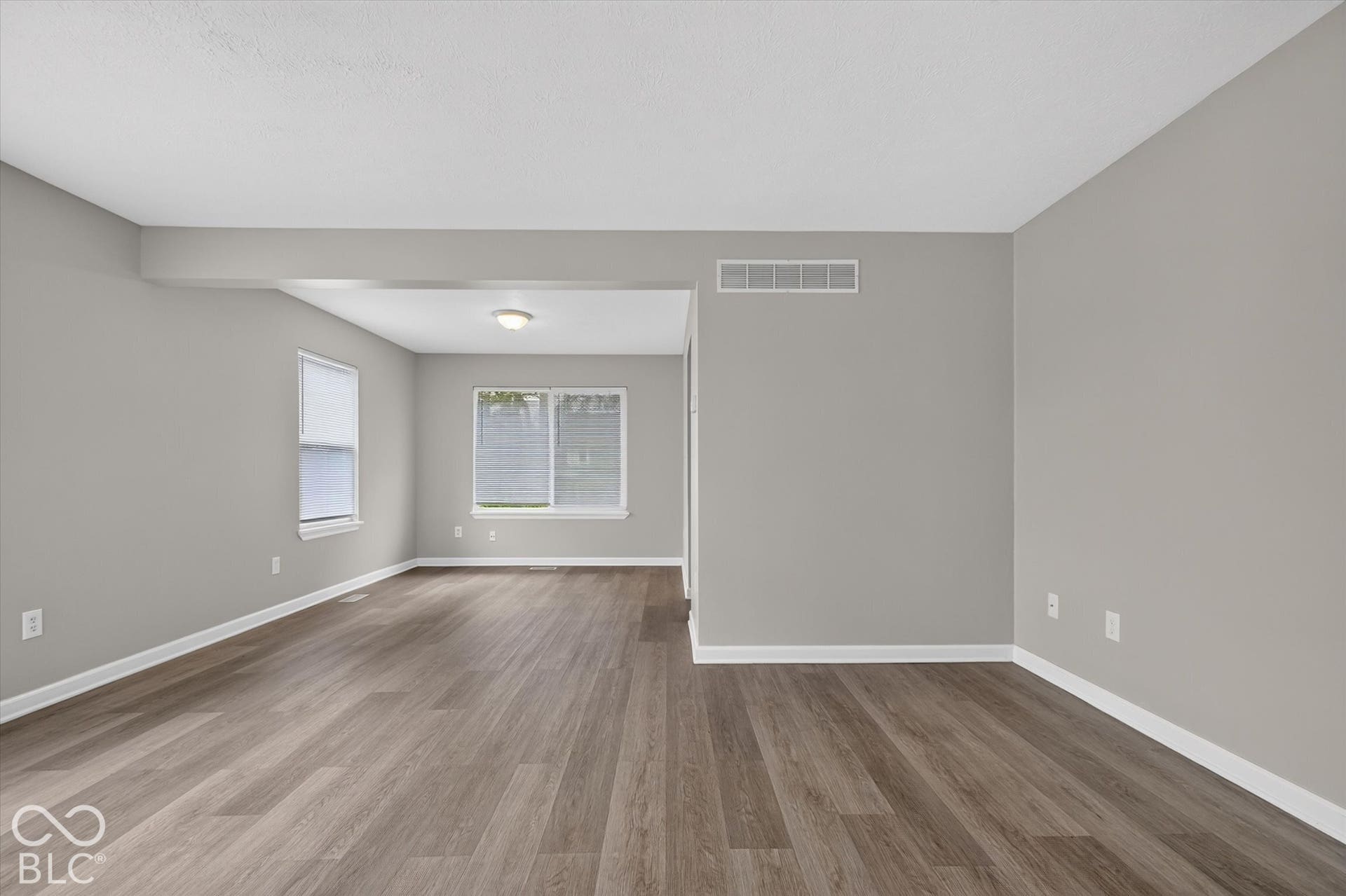 Living room and entryway with abundant natural light and neutral paint
