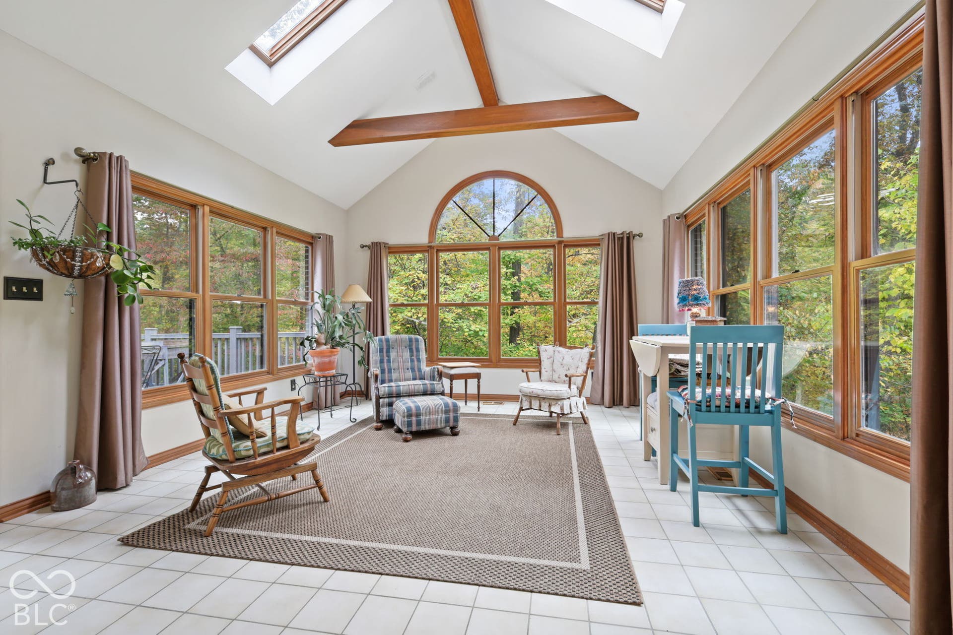 Virtually Altered - Beautiful sunroom with vaulted ceiling overlooks the wooded property and pond
