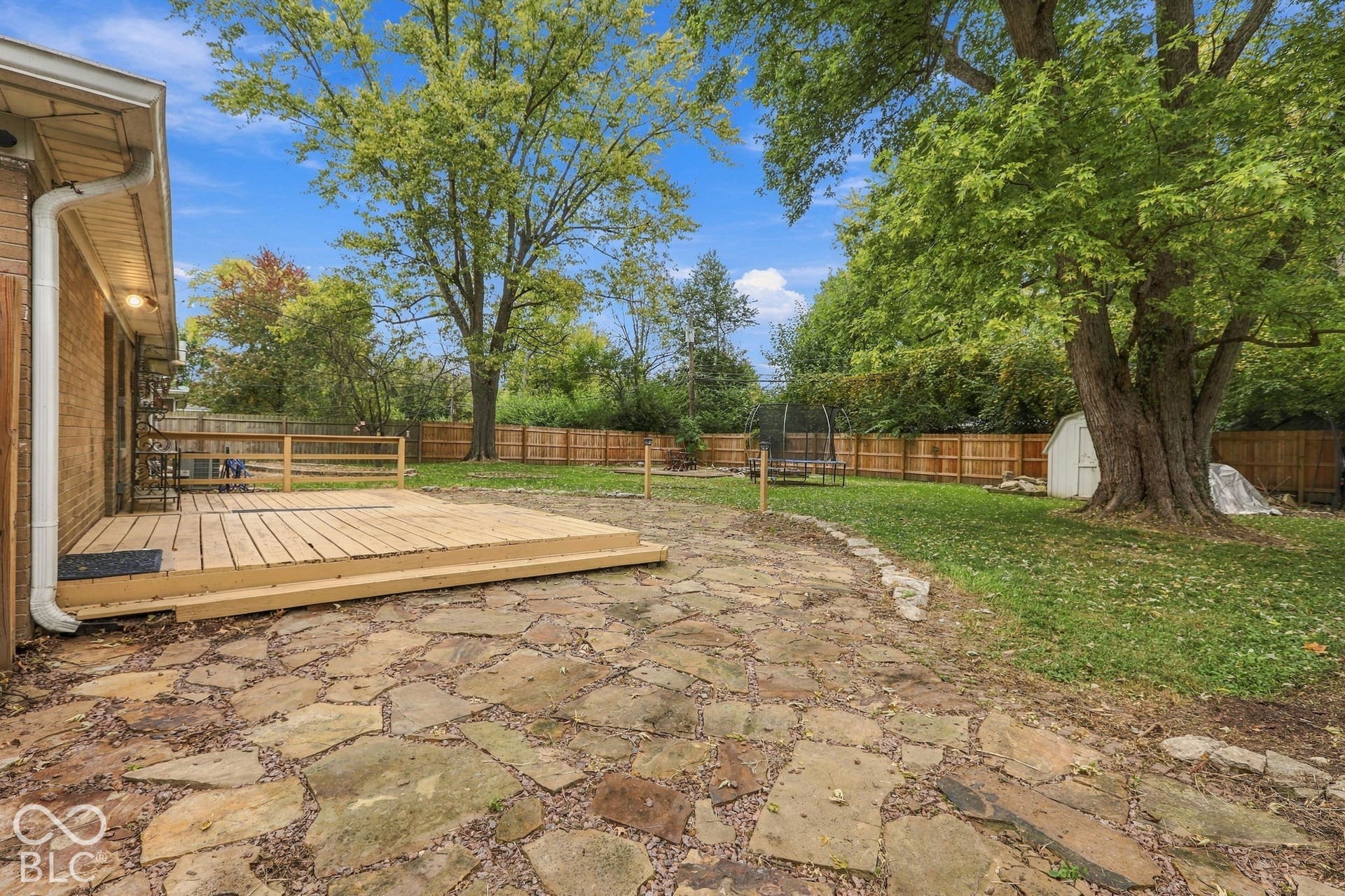 Backyard with deck, fire pit, garden areas, storage shed, full privacy fence