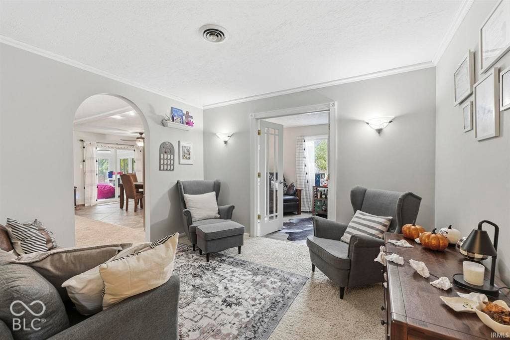Bright, open living area featuring neutral wall finishes, recessed ceiling lighting, and arched architectural details