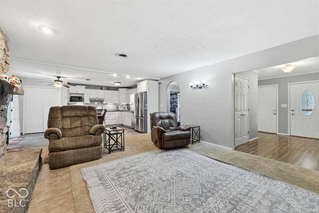 Spacious open-concept living area featuring wood-finish flooring throughout, recessed lighting, and multiple seating zones