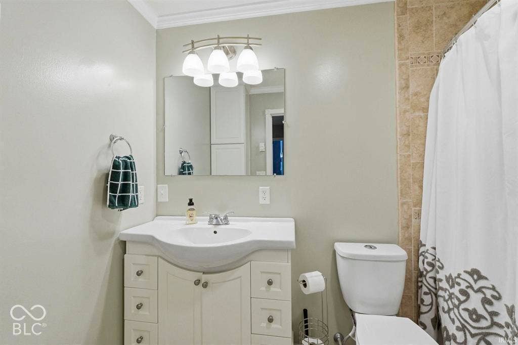 Elegant bathroom vanity featuring a curved white porcelain sink, soft-close cabinetry with ample storage, and polished chrome hardware
