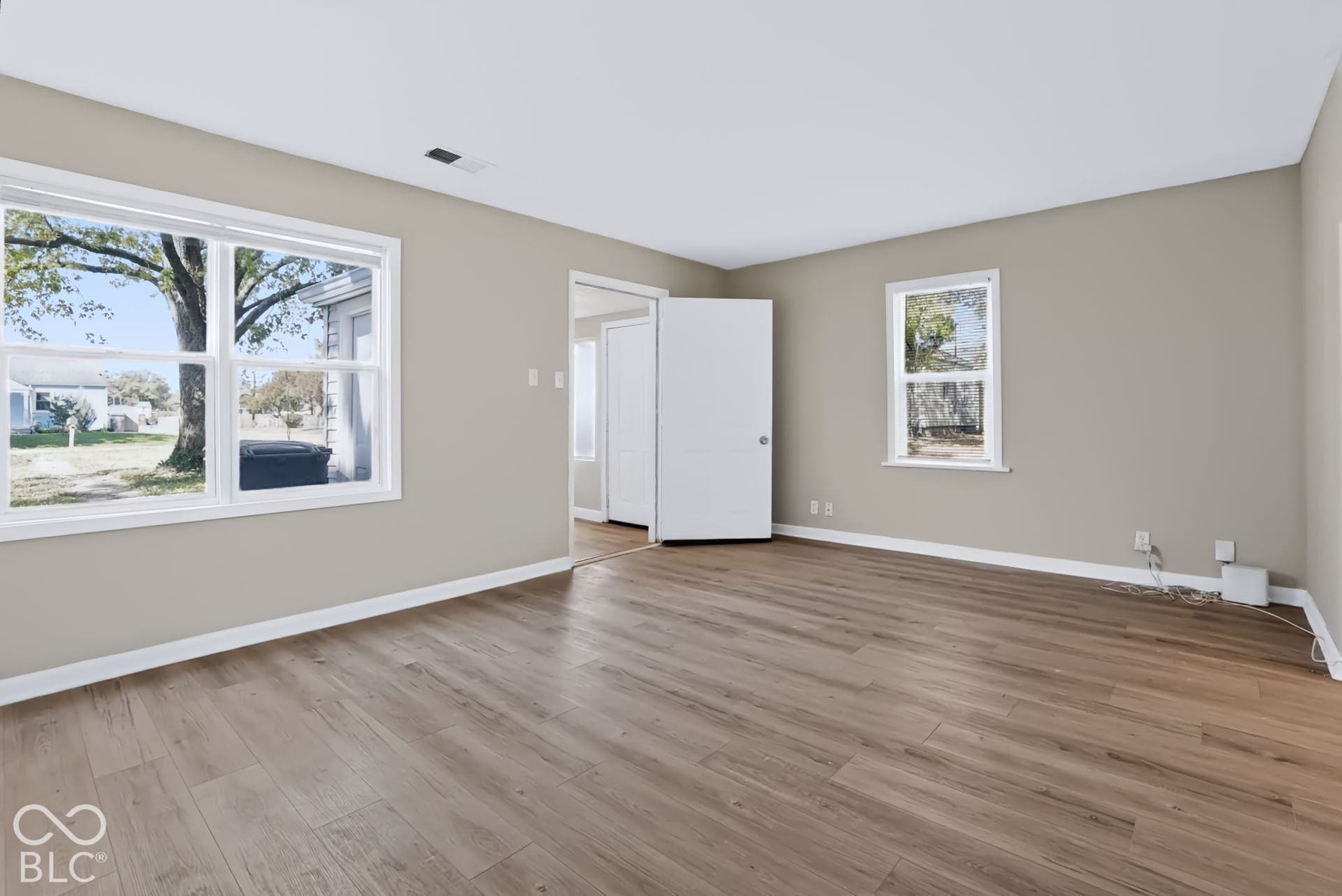 Wood-finish flooring throughout, complemented by neutral-toned walls and crisp white trim