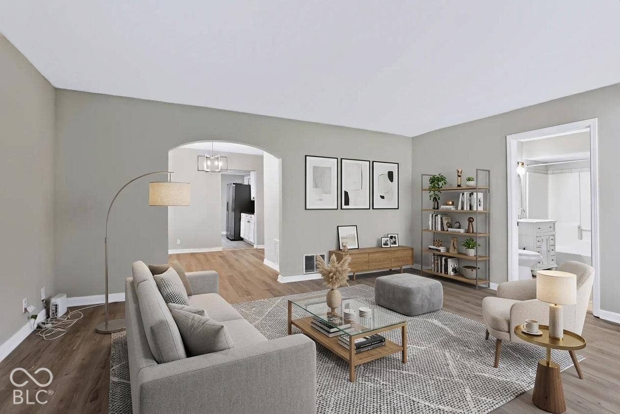Wood-finish flooring throughout, light gray wall paint, and an arched doorway
