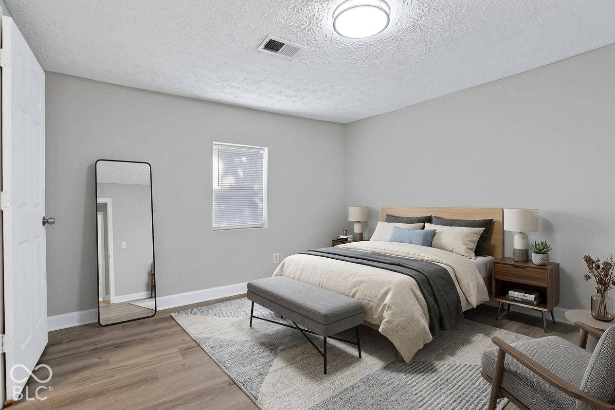 Wood-finish flooring with light gray walls, a single window, and overhead flush-mount lighting
