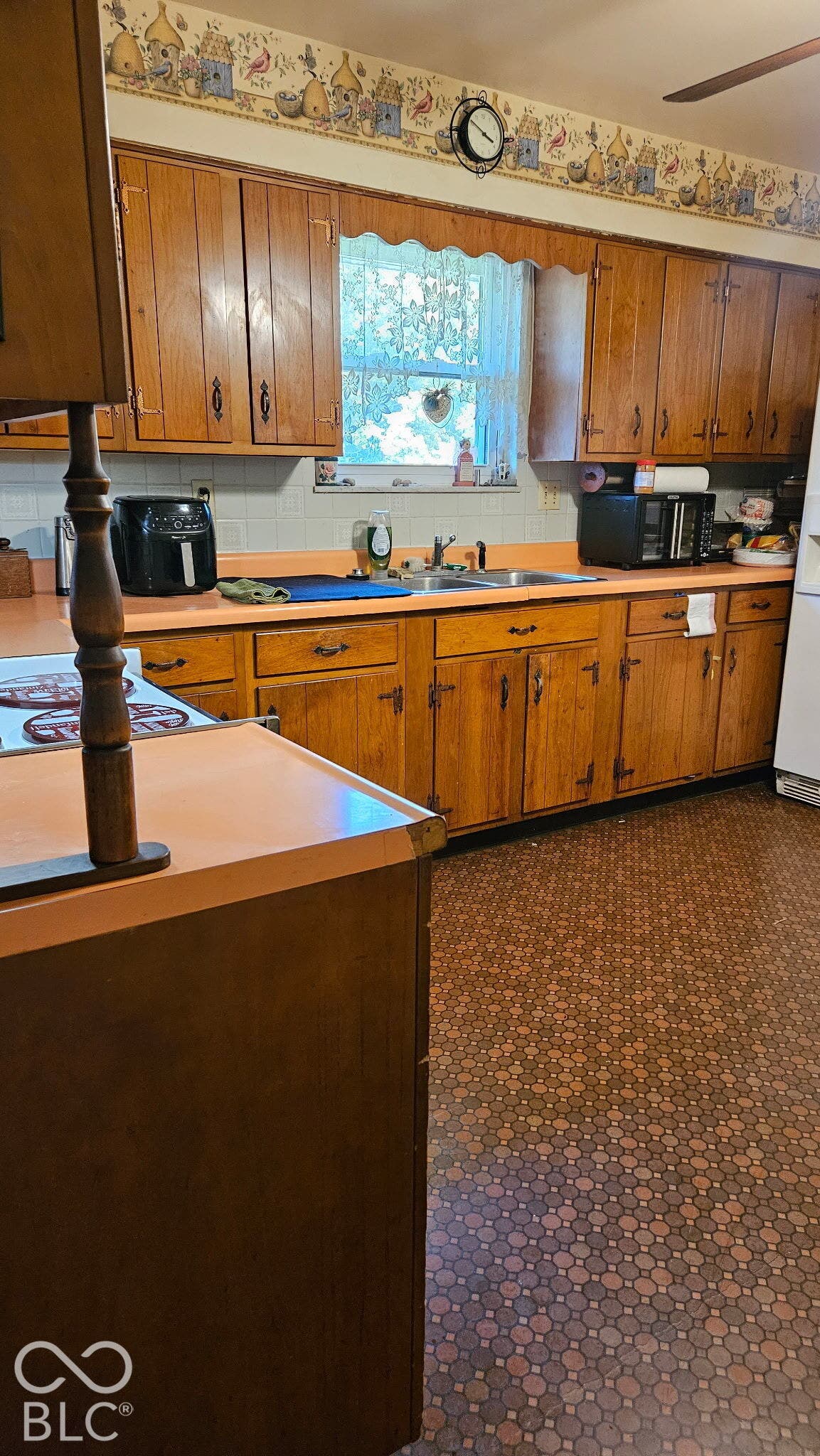Kitchen featuring extensive wood cabinetry, an integrated sink, and an overhead lighting fixture
