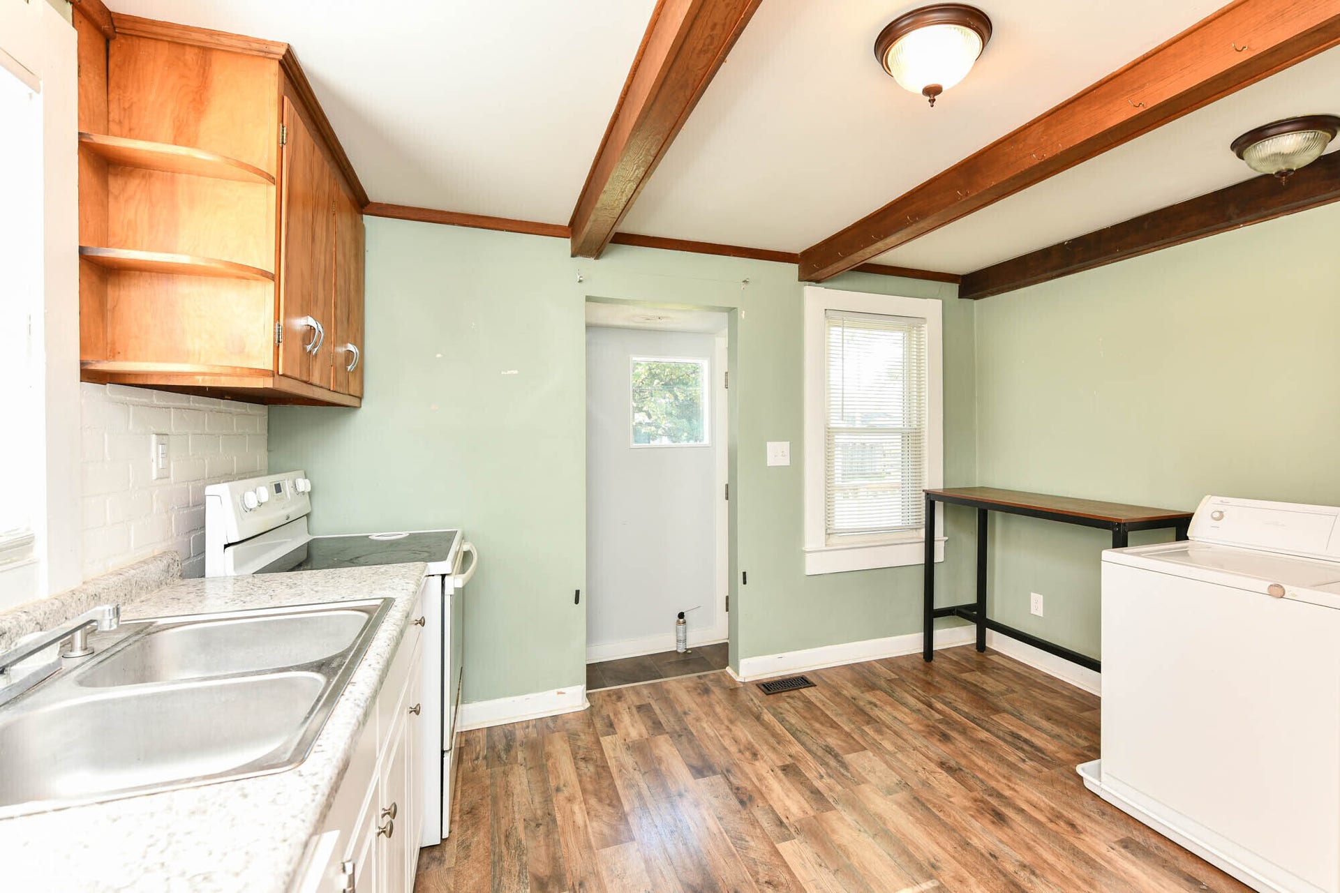 896 Young Street, Franklin, IN 46131 Kitchen has exposed ceiling beams, wood cabinetry, and a double-basin stainless steel sink.