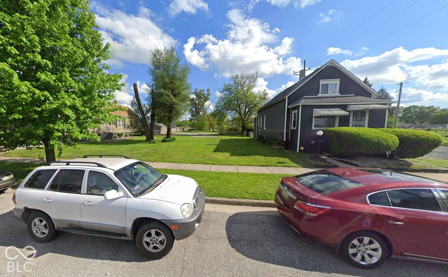 Gabled roofline, dark siding, multiple windows, and sidewalk access