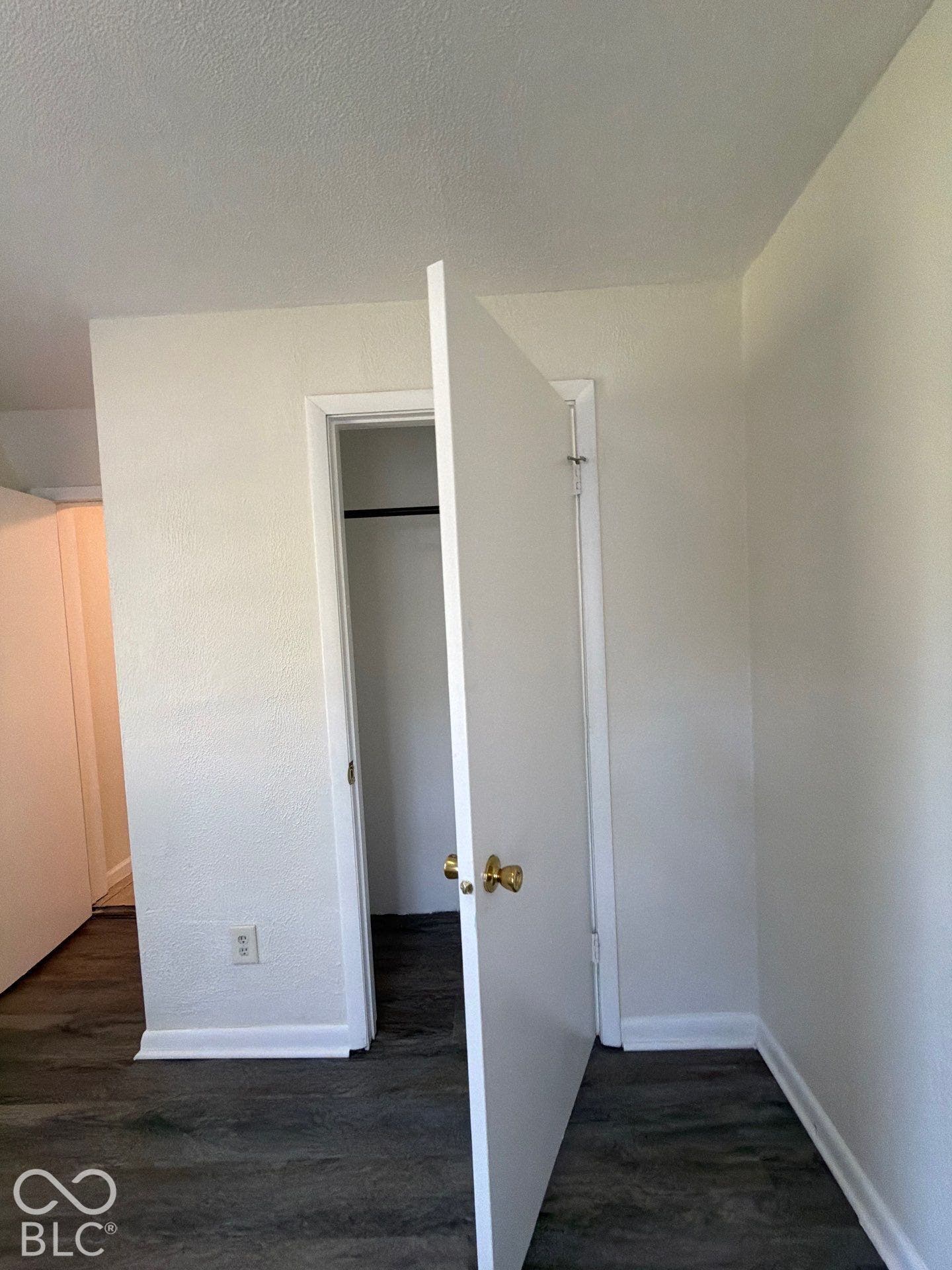 Wood-finish flooring with white trim and brass hardware