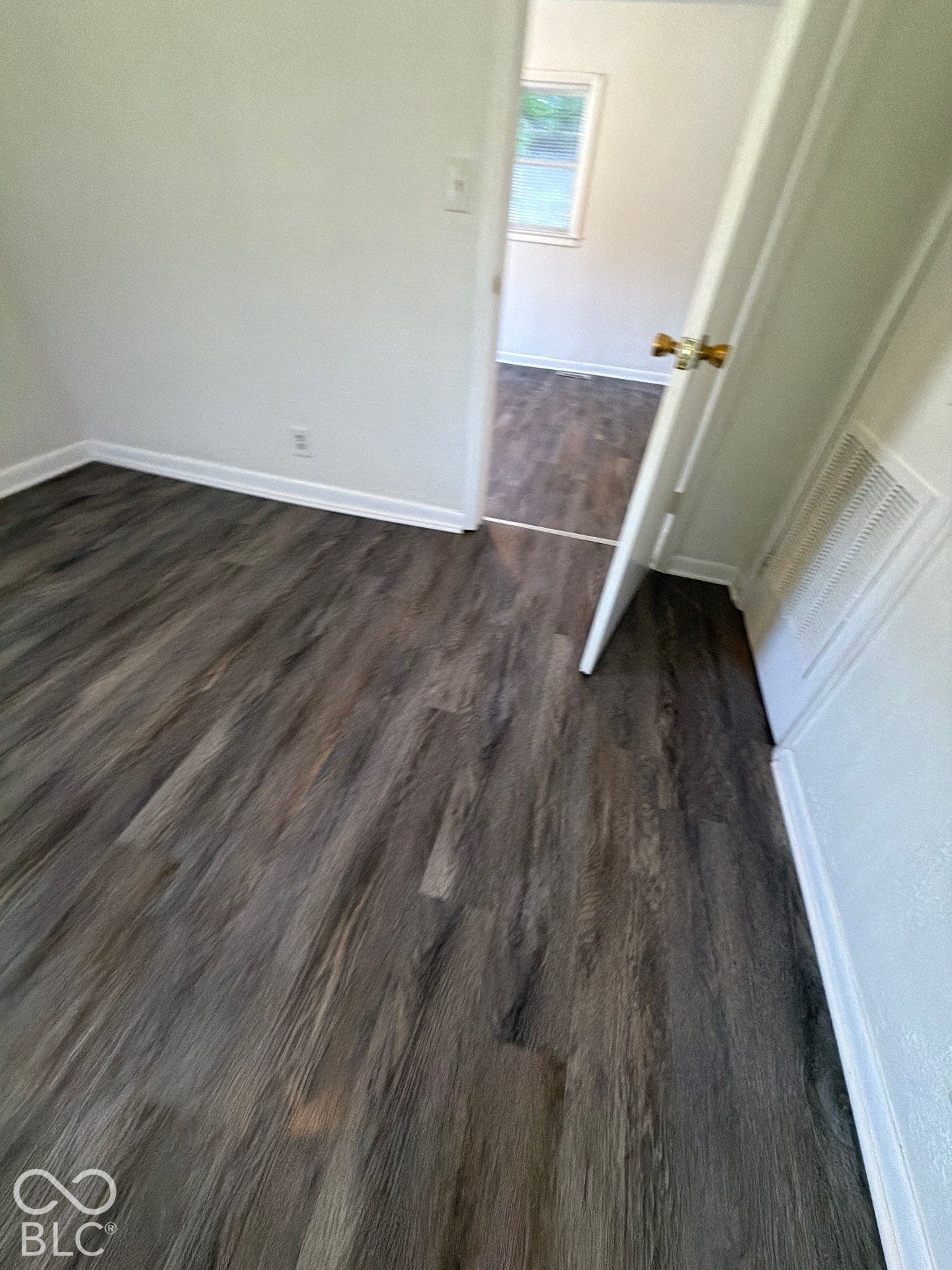 Wood-finish flooring throughout, white interior walls, and white trim