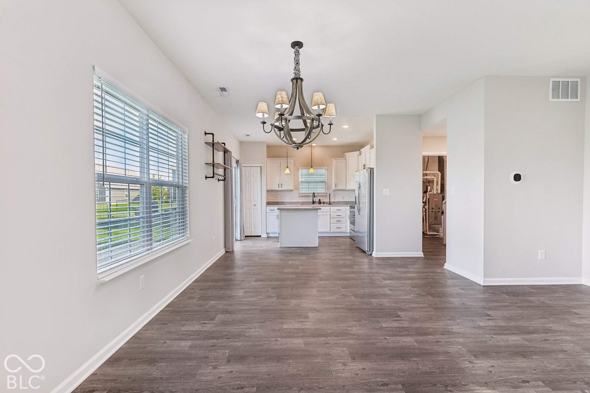 Open floor plan featuring vinyl  wood-finish flooring, a multi-light chandelier