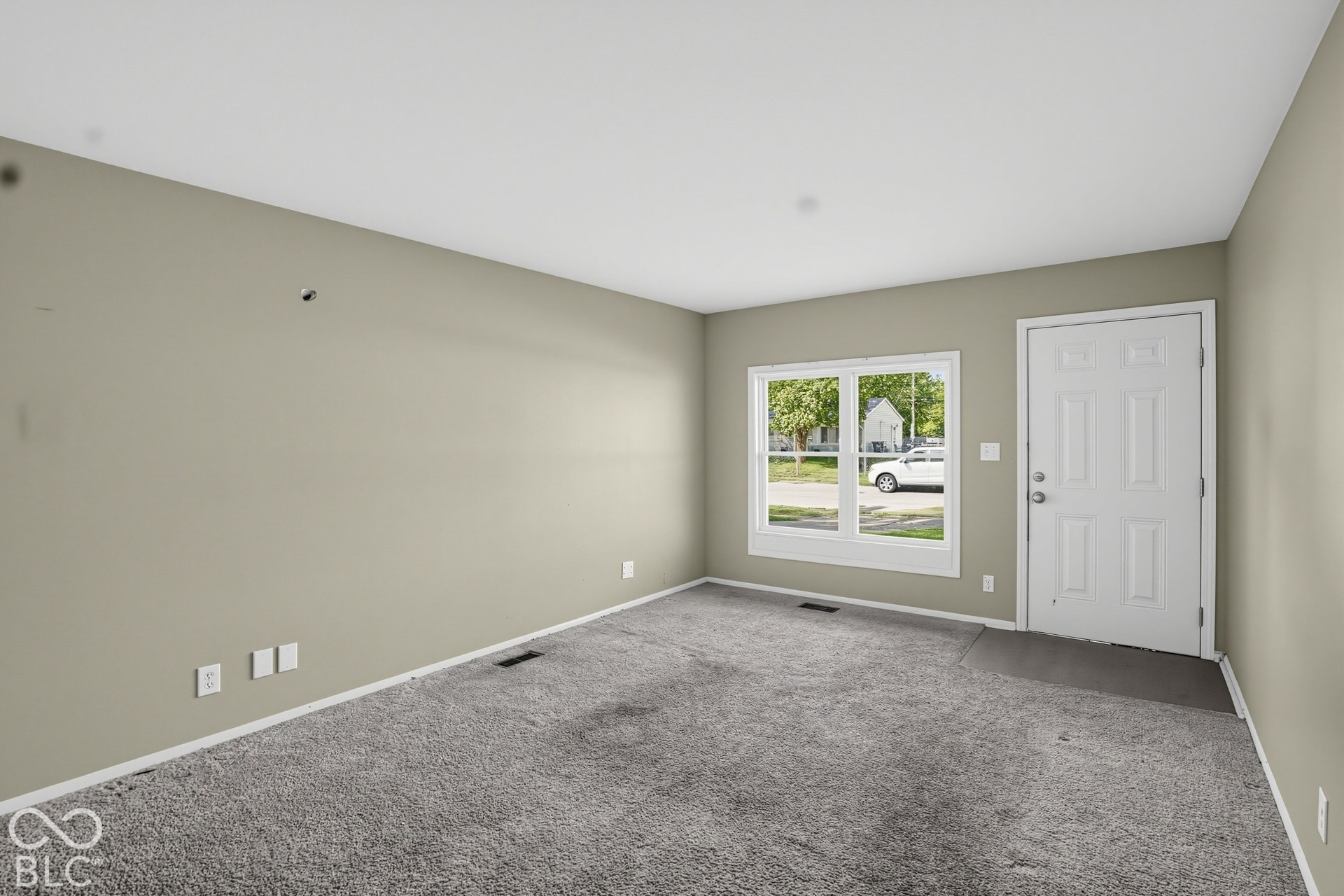 Interior space featuring wall-to-wall carpeting, neutral-toned walls, and a multi-pane window