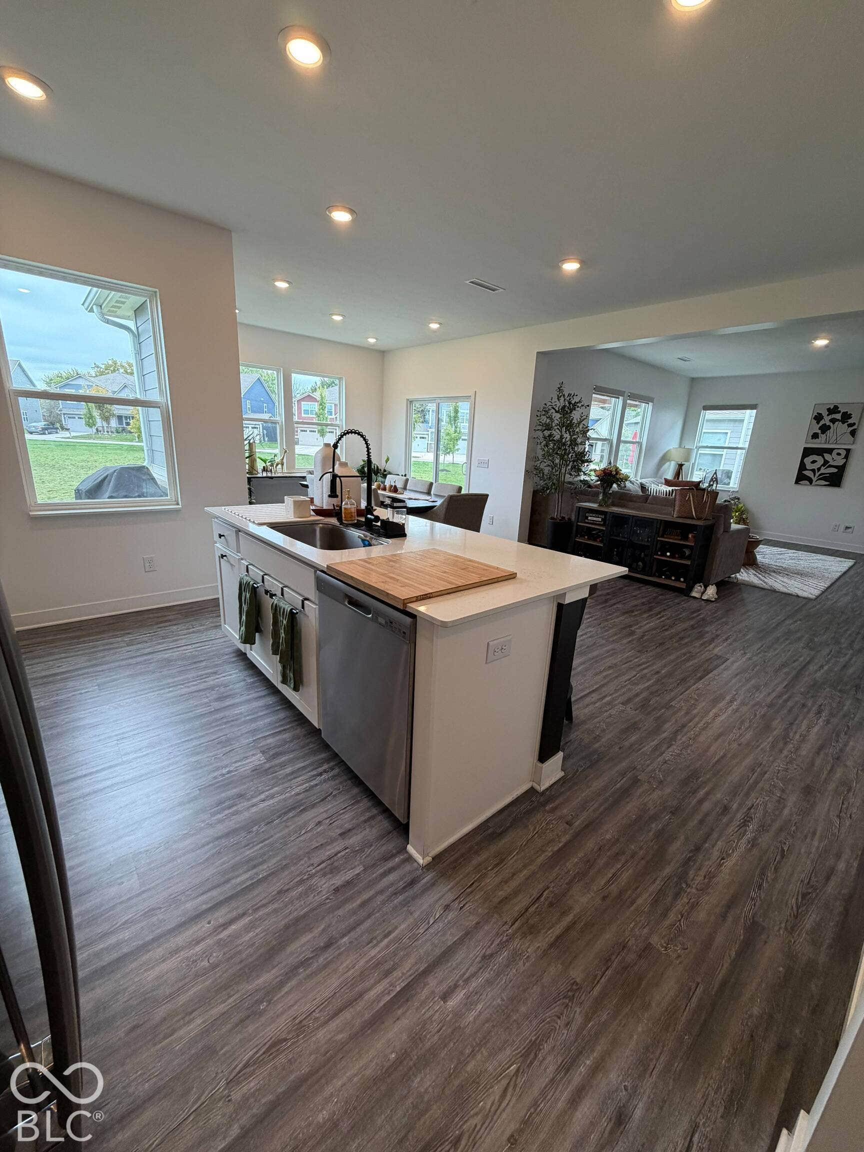 Kitchen island with integrated stainless steel dishwasher, quartz countertop, and a matte black gooseneck faucet