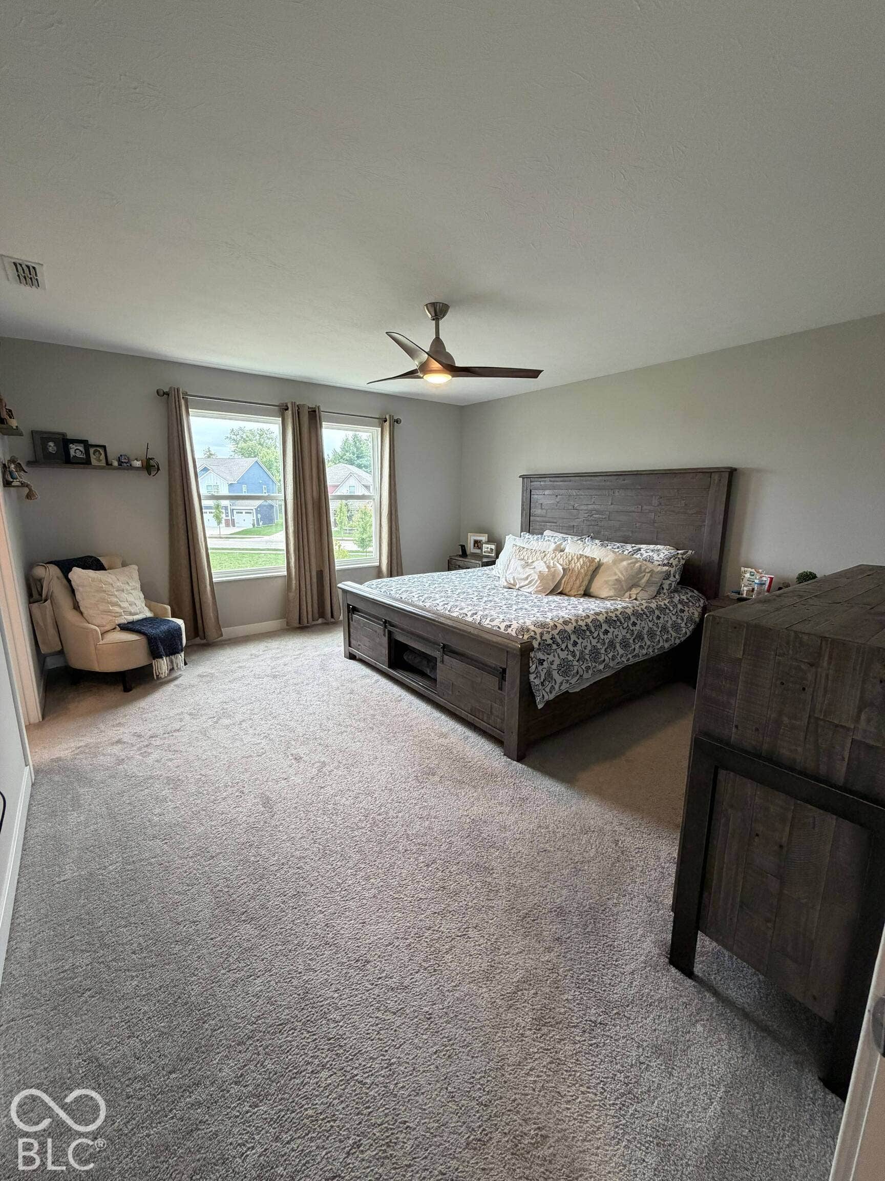 Wall-to-wall carpeting, dual windows, and a ceiling fan with integrated lighting