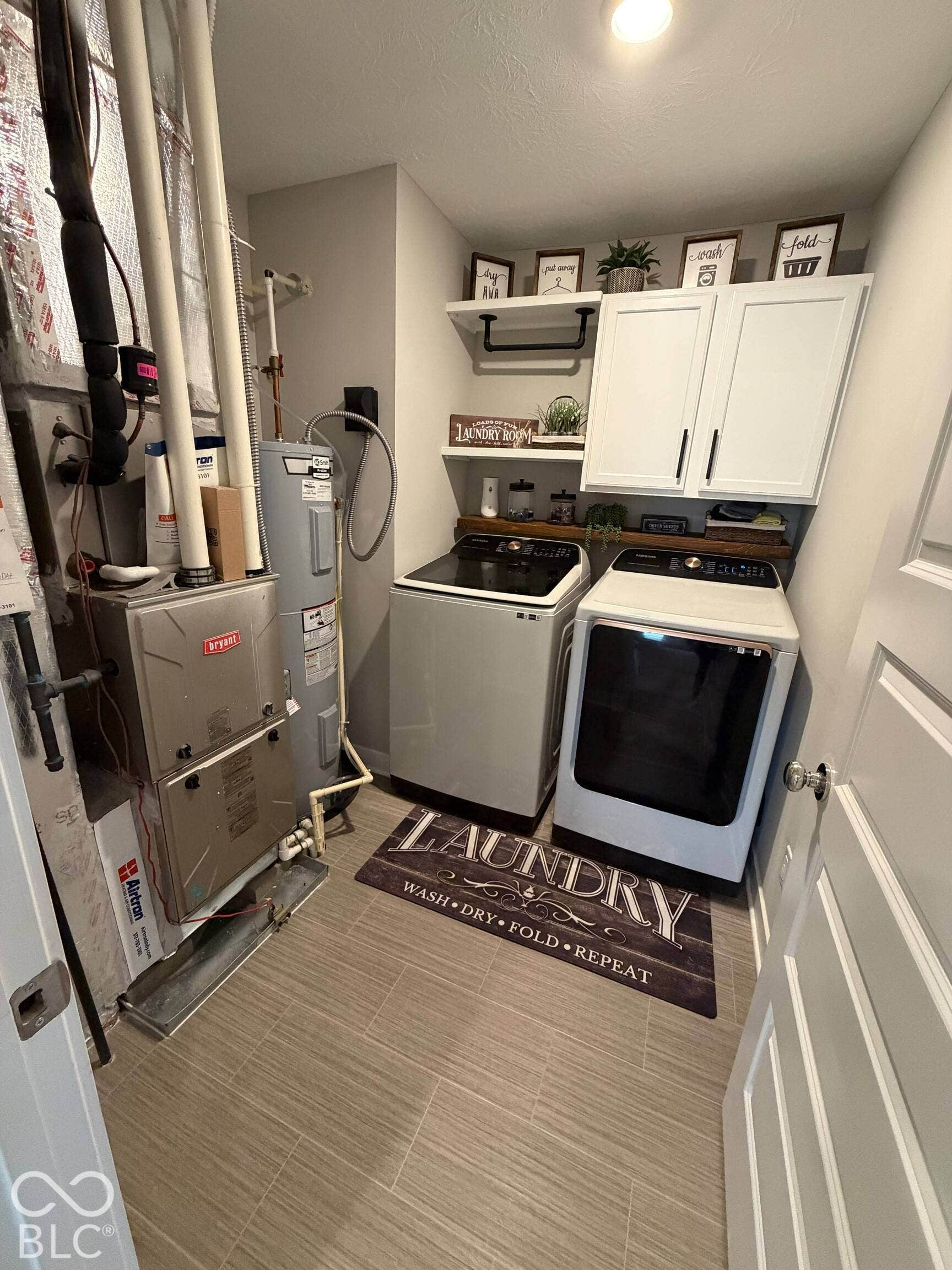Laundry area featuring tile flooring, white wall cabinetry, and built-in shelving
