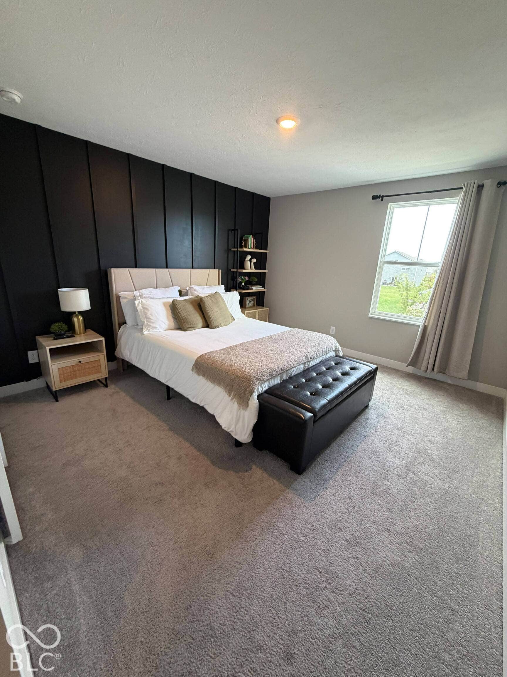 Gray carpet flooring, accent wall with vertical paneling, recessed lighting, and a single window with curtain rod