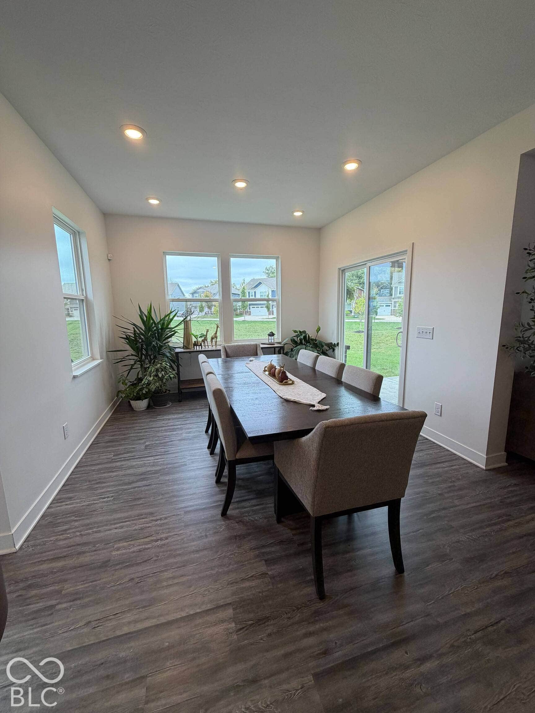 Recessed ceiling lighting, multiple windows, sliding glass door, and wood-finish flooring