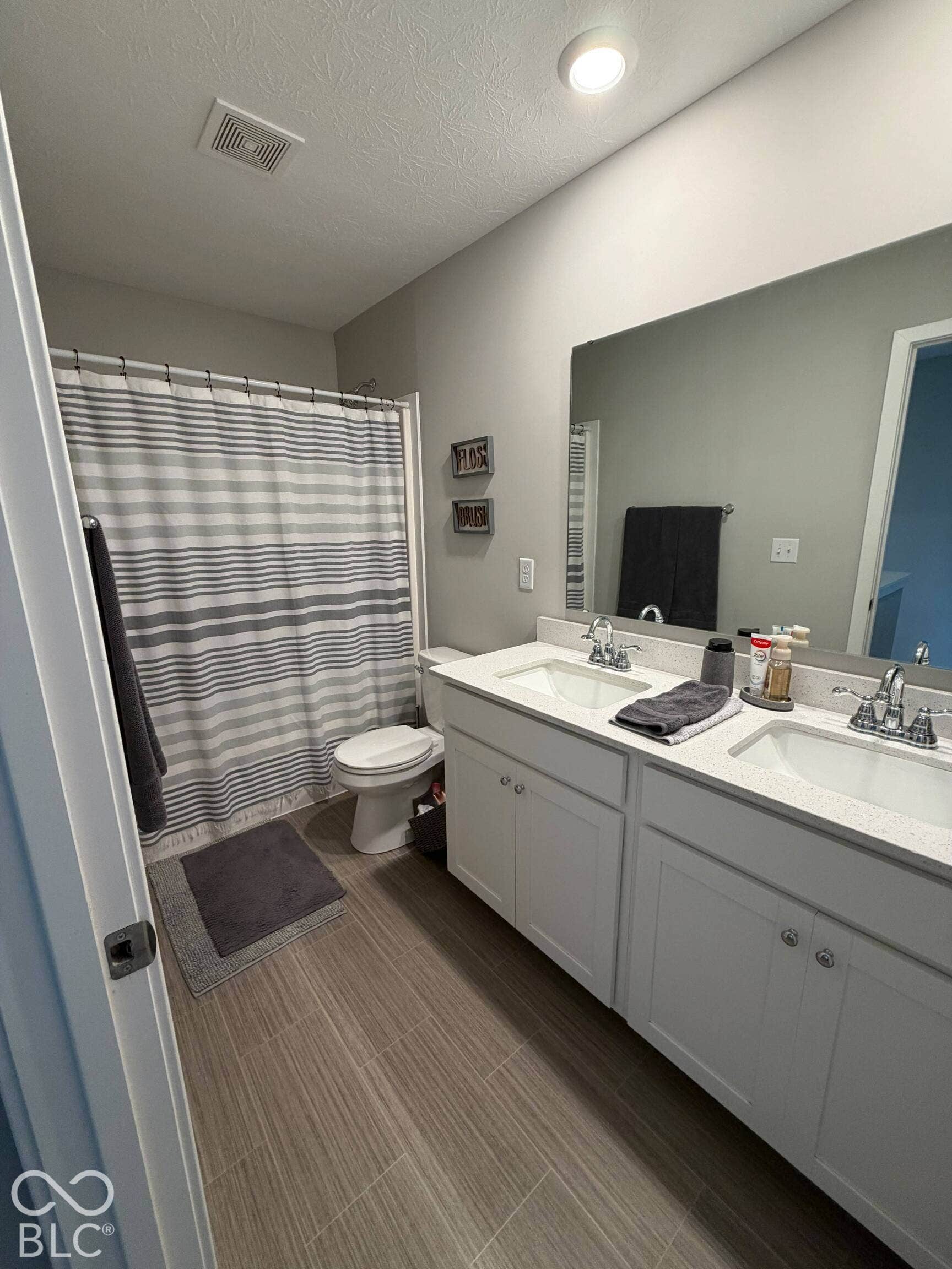 Dual vanity with white shaker-style cabinetry, white countertops, and integrated sinks
