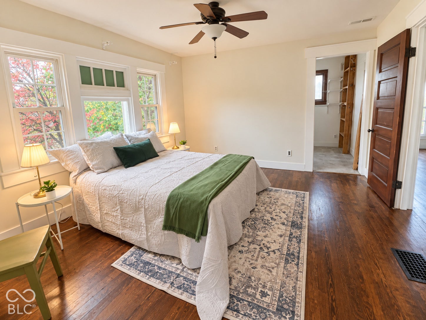 Hardwood flooring, multi-pane windows with transom glass, ceiling fan, and solid wood five-panel door