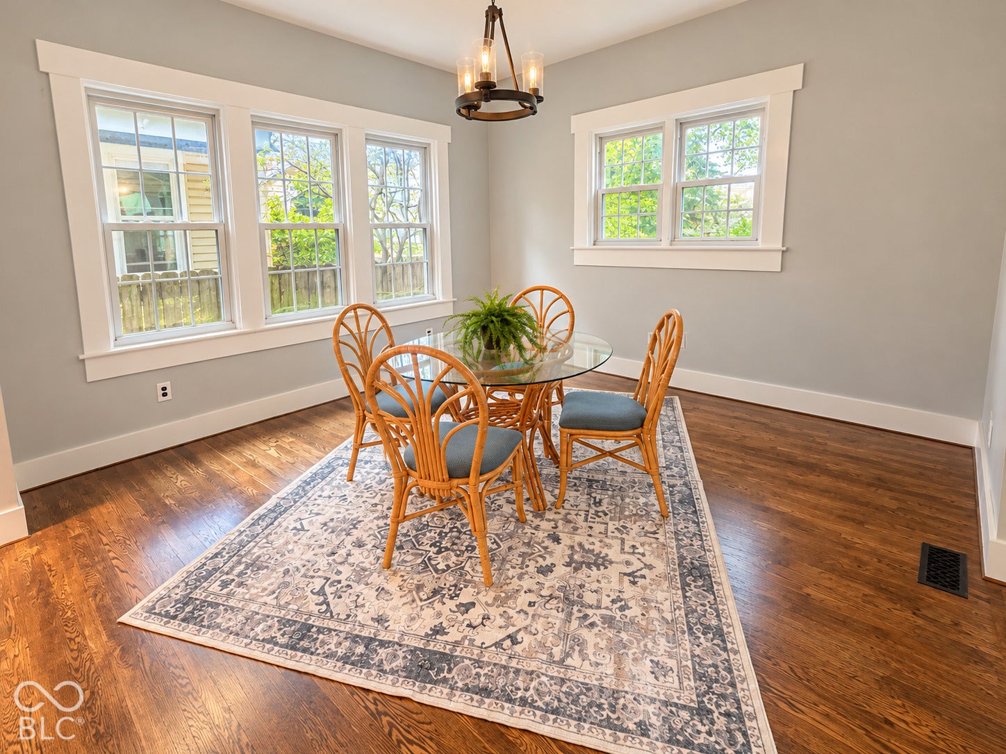 Virtually Altered - Wood-finish flooring, multi-pane windows with wide casing, and a drum-style iron chandelier