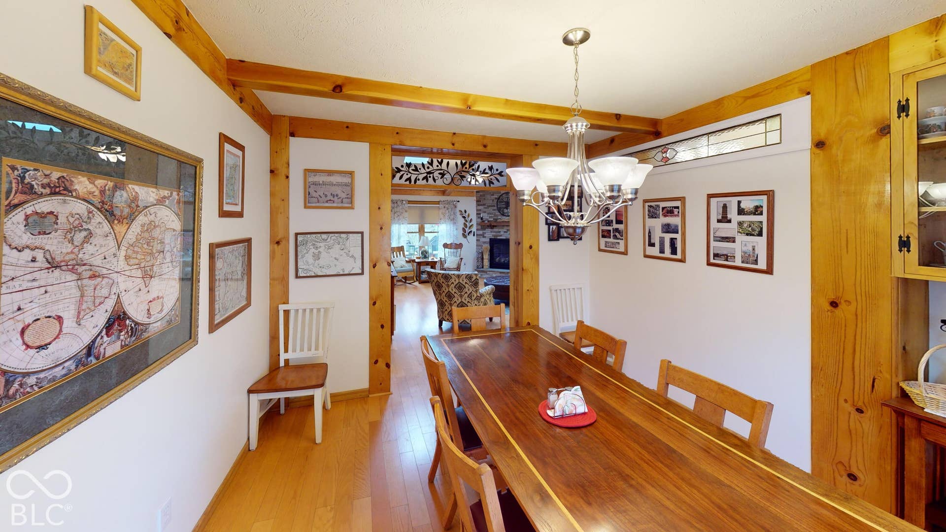 Formal dining area featuring wood-finish flooring, exposed wood beams, and a chandelier
