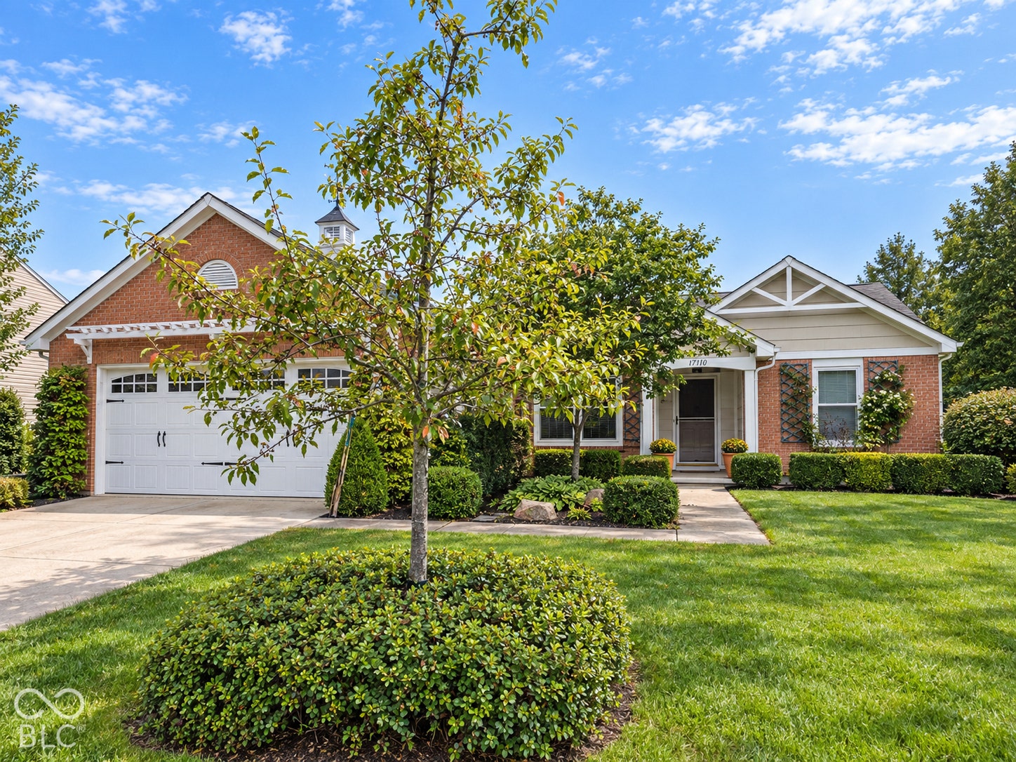 Brick exterior with white trim, a two-car garage, and a covered front entry